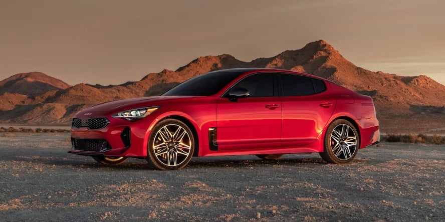 A red Kia Stinger fastback parked in the desert