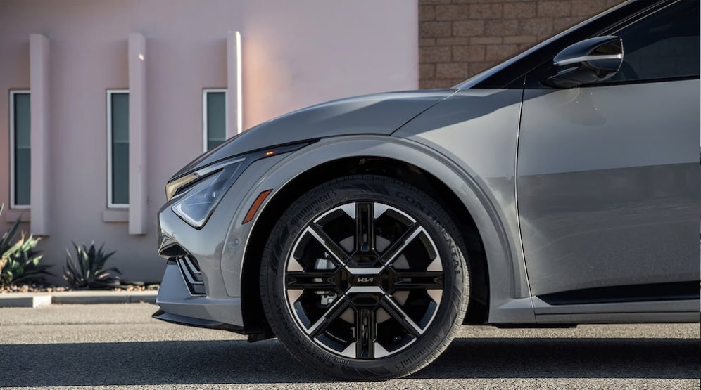 A closeup of the wheel of a silver 2026 Kia EV6 SUV